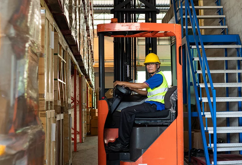 Senior man driving forklift truck